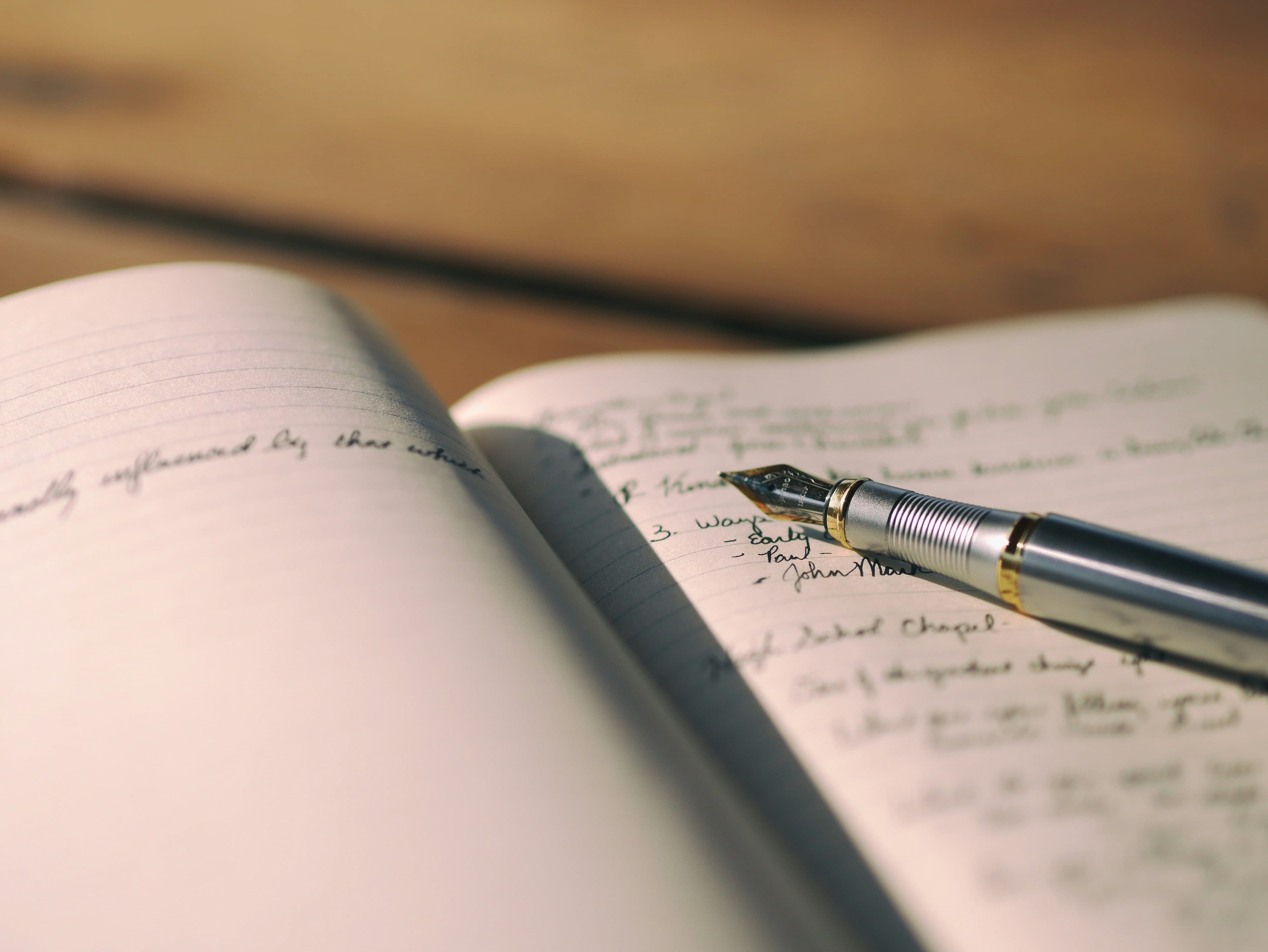 una pluma estilográfica sobre un cuaderno abierto
